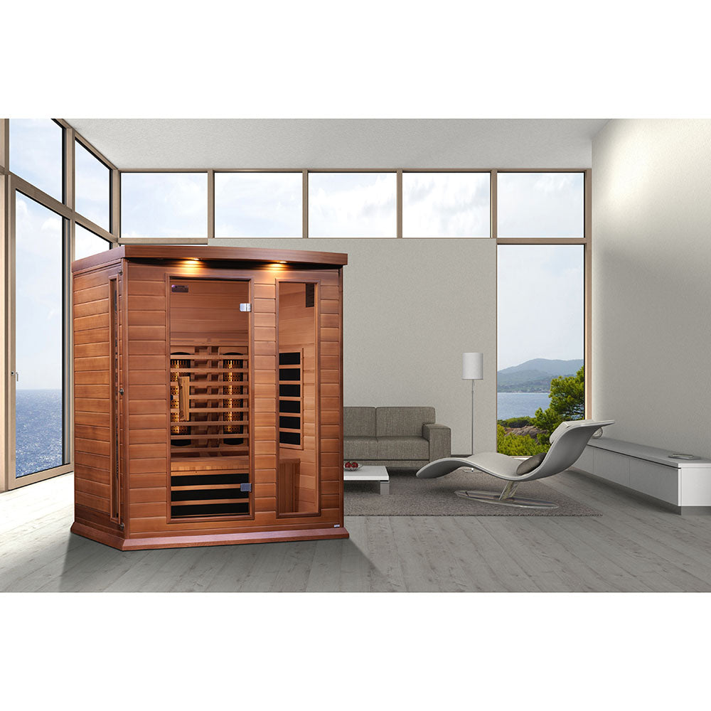 Maxxus 3 Person Full Spectrum Infrared Sauna displayed in a modern living room with large windows, showcasing a sleek design and wooden finish.
