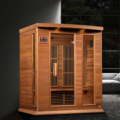 Maxxus MX-K306-01 Far Infrared Sauna, a wooden sauna with a front door and slatted panels, set in a modern interior with a sofa in the background.