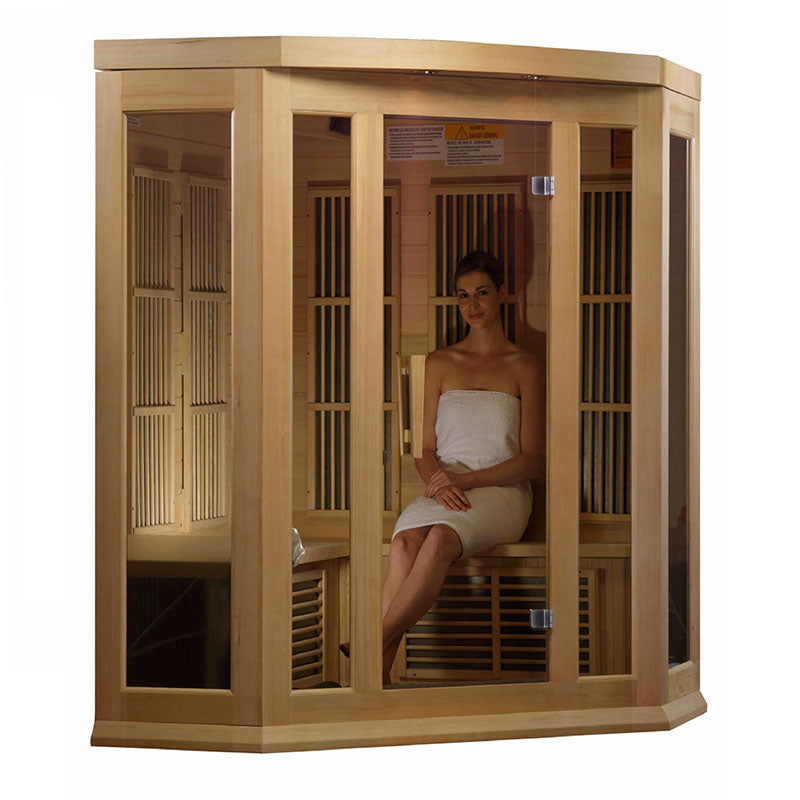 Maxxus MX-K356-01 Far Infrared Corner Sauna with a woman sitting inside, wrapped in a towel, showcasing the sauna's wooden design and glass panels.