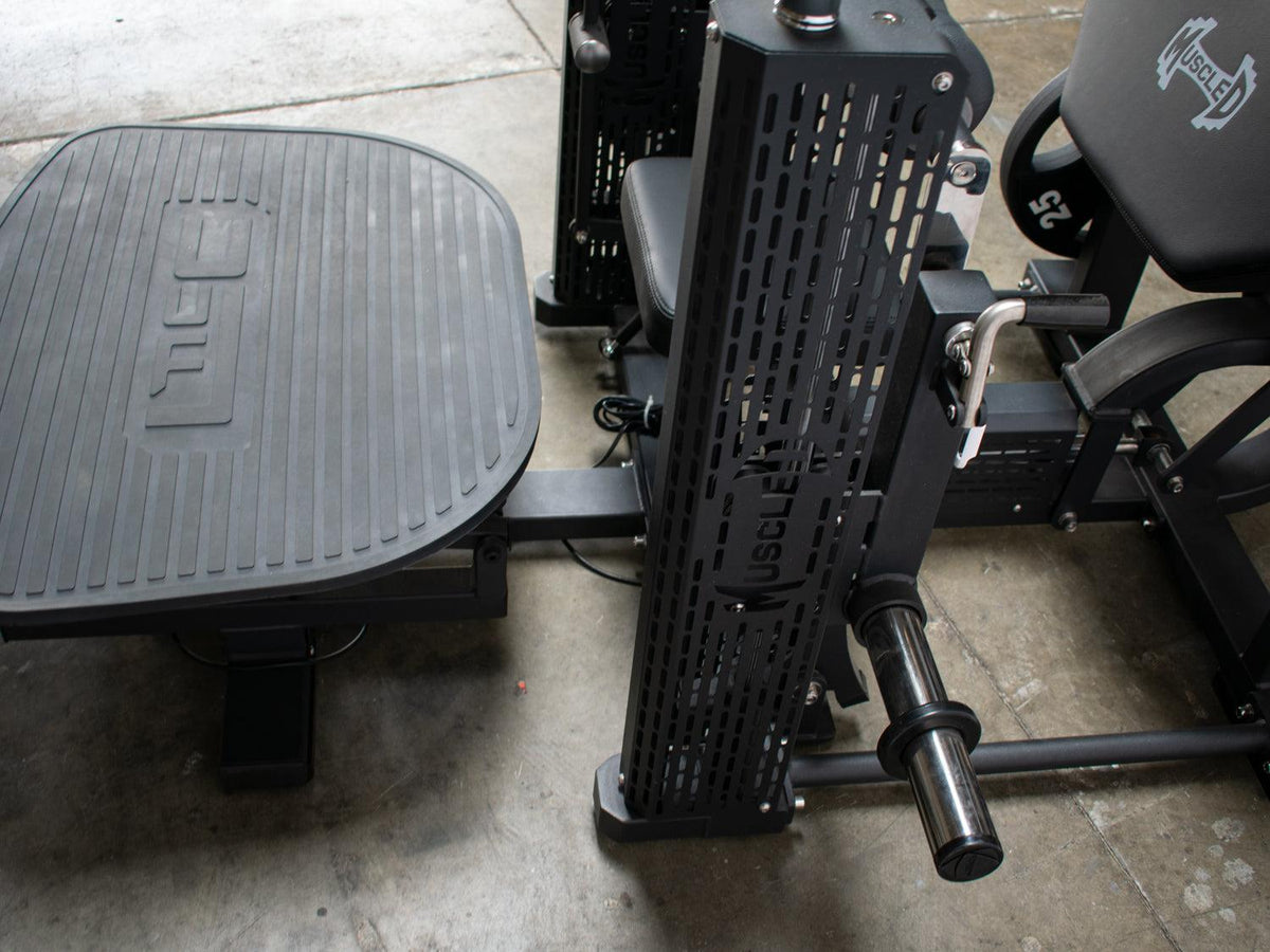 Motorized hip thruster gym machine with a foot platform and padded seat.