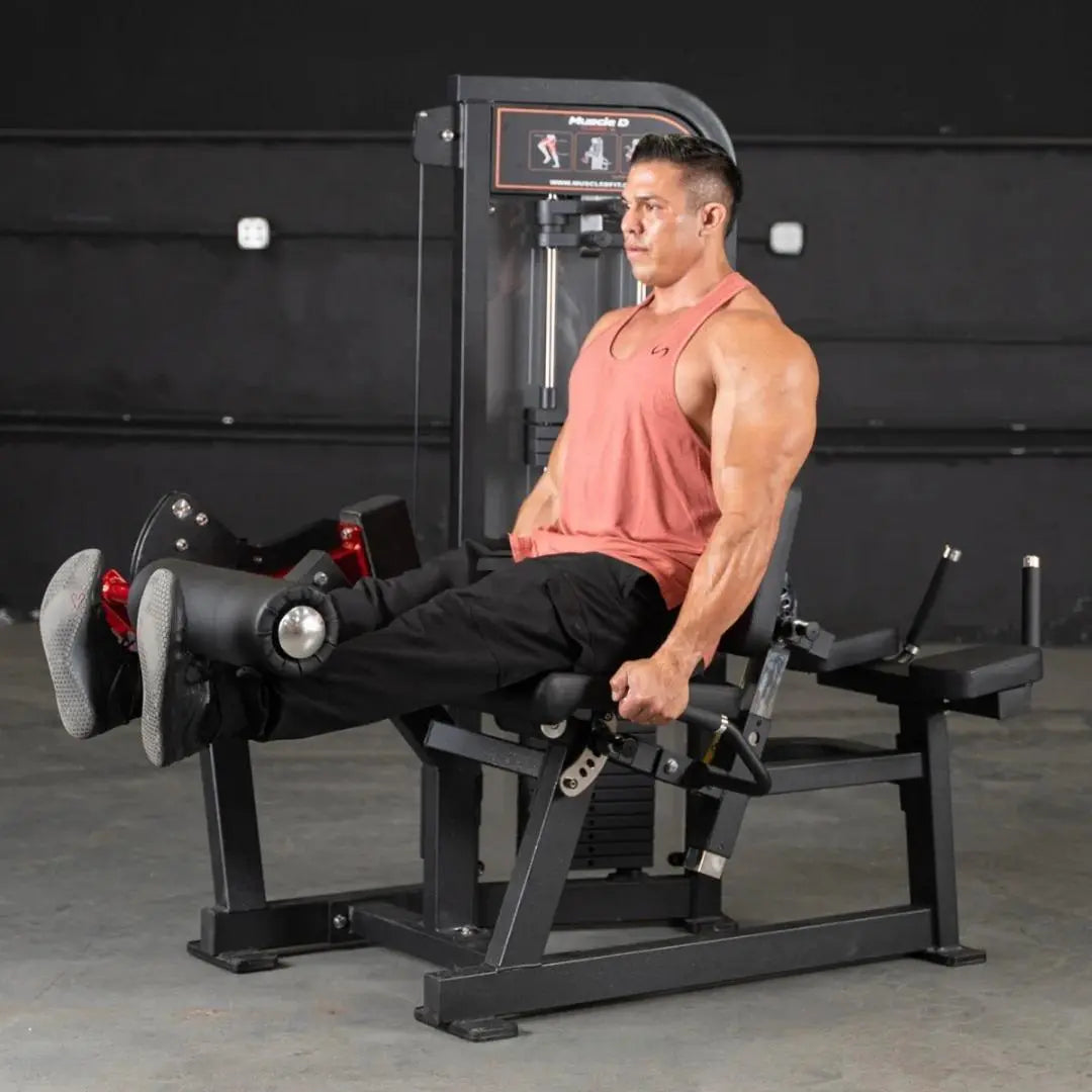 Man performing a leg extension exercise on a black commercial leg extension machine with digital display and footrest in a gym setting.