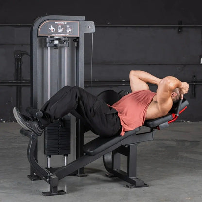 Man performing abdominal crunch exercise on a black Muscle D selectorized abdominal machine with instruction panel in a gym setting.