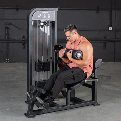 Man performing a bicep curl with a dumbbell while seated on a black selectorized back and ab combo machine in a gym setting.