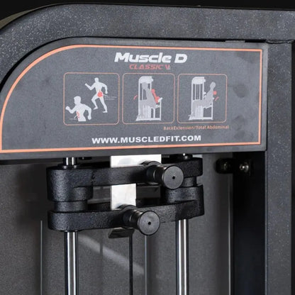 Muscle D Classic V2 selectorized back and abdominal combination machine with black frame, orange accent trim, and instruction placards showing three exercise positions on the top panel.