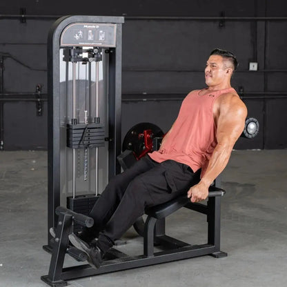 Man performing an abdominal exercise on a black Muscle D selectorized back and ab combo machine in a gym setting.