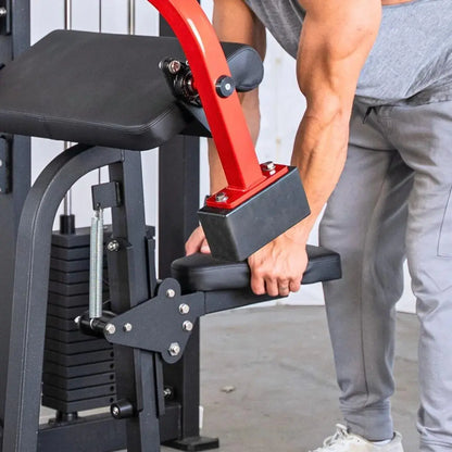 Man performing a biceps curl on a commercial selectorized machine with red frame, black padded seat and arm rest, and weight stack visible on the left side.