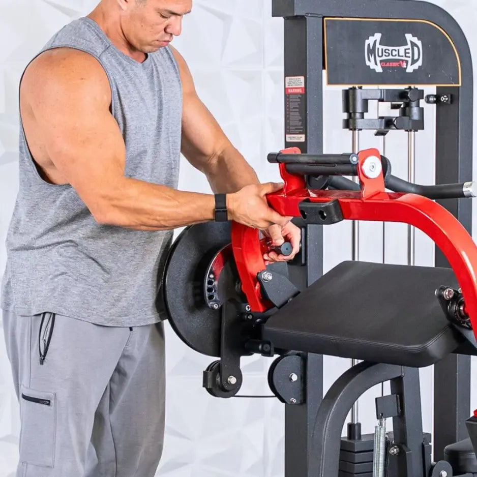 Man performing a biceps and triceps exercise on a red and black selectorized combo machine with black seat and padded arm rest.