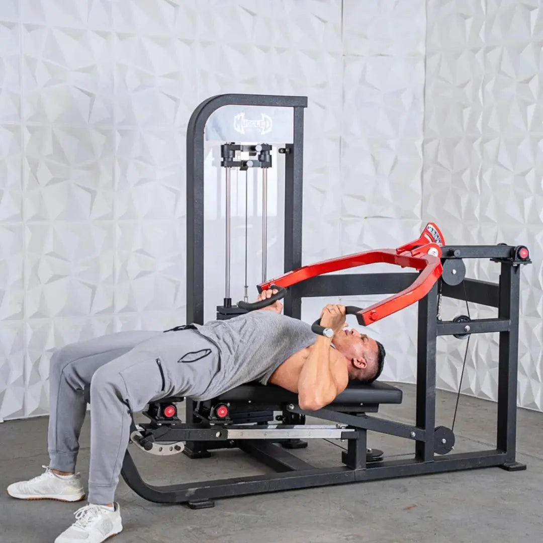 Man performing a chest press exercise on a black and red selectorized chest and shoulder machine with cable arms in a gym setting.