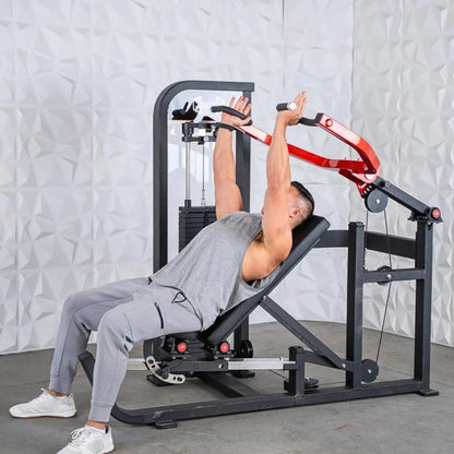 Man performing a chest press on a black selectorized chest and shoulder machine with red handles and weight stack visible.