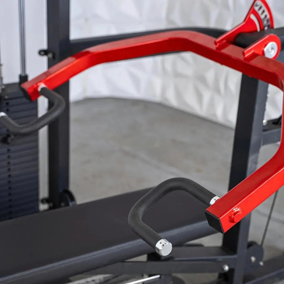 Red and black selectorized chest and shoulder press machine with curved arm handles and padded seat in a gym setting.