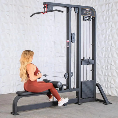 Woman performing a lat pulldown on a dark gray selectorized combo machine with cable pulley system and weight stack, seated on attached bench.