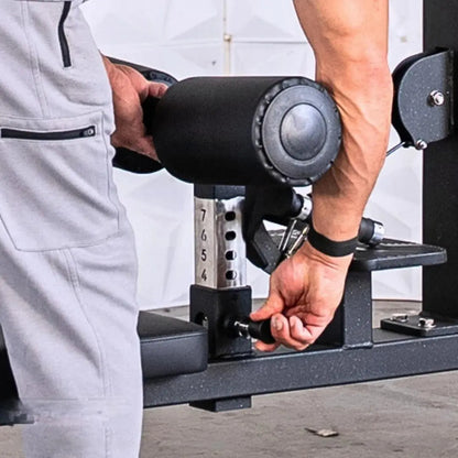 Man performing a lat pulldown exercise on a selectorized lat pulldown and low row combo machine with black handles and metal weight stack selector.