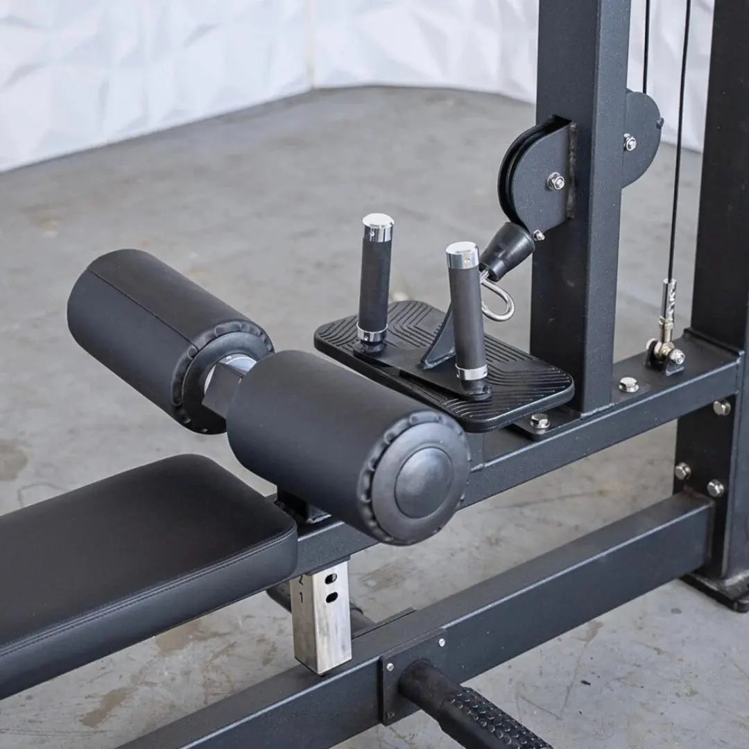 Black selectorized lat pulldown and low row combo machine with padded seat, dual cylindrical weight arms, textured footplate, and chrome handles on a concrete gym floor.