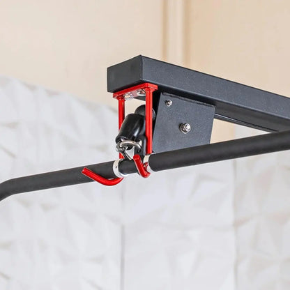 Close-up of a red and black lat pulldown attachment with curved hook and black rubber grip handle mounted on a triangular bracket.