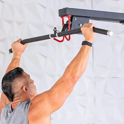 Man performing a lat pulldown exercise on a wall-mounted pull-up bar with black foam grip and red attachment bracket.