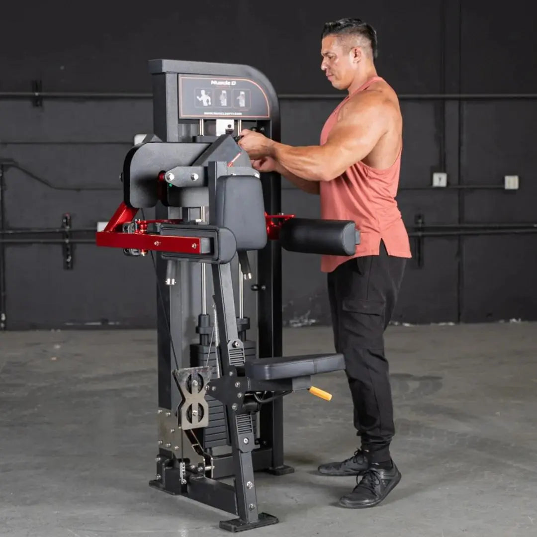 Man performing lateral raise on a selectorized machine with gray frame, red accents, and digital display in a gym setting.