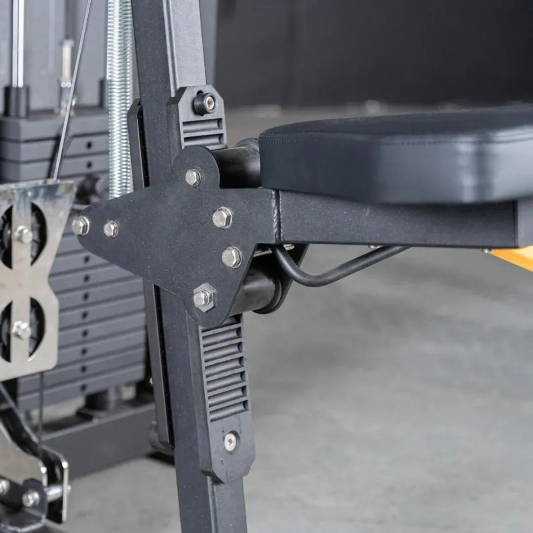 Close-up of selectorized lateral raise machine showing black metal arm lever with bolt fasteners, chrome threaded rod, and black seat pad attached to gray frame.