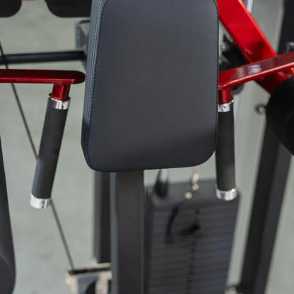 Selectorized lateral raise machine with padded black seat back, red metal frame, and black foam-grip handles on adjustable arms.