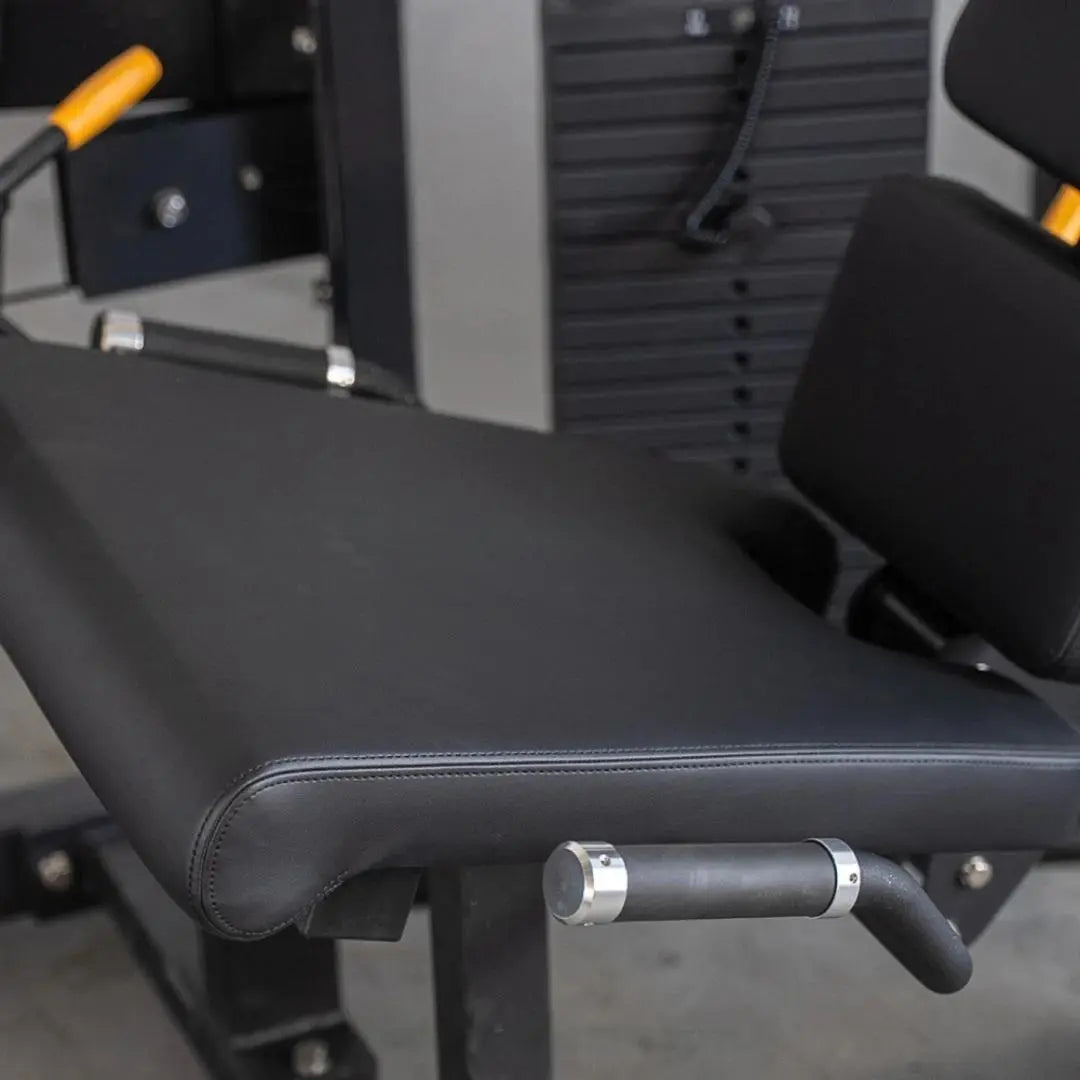 Close-up of the padded seat and lever arm on a leg extension machine with black upholstery and chrome handle detail.