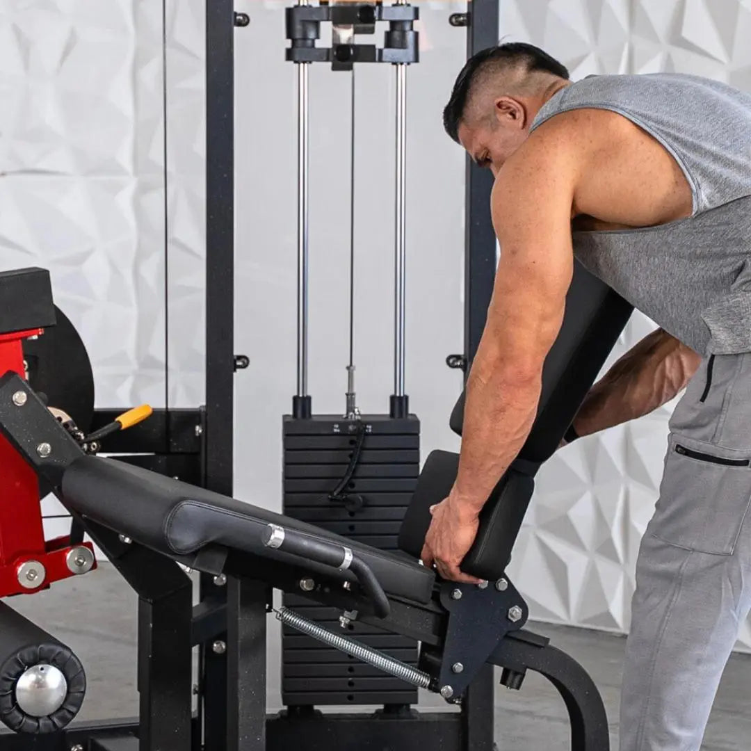 Man performing a leg extension exercise on a black selectorized leg extension machine with padded seat and footrest in a gym setting.