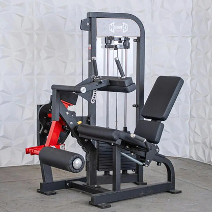 Leg extension and seated leg curl combo machine with black frame, red accents, padded seat and back support, and cable-driven resistance system on white tile background.