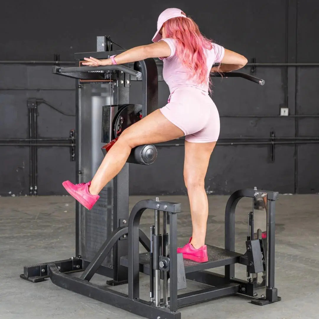 Woman performing a hip abduction exercise on a black selectorized multi-hip machine with weight stack in an indoor gym setting.
