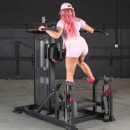 Woman performing a hip exercise on a black selectorized multi-hip machine with footplate and handlebar, in a gym setting.
