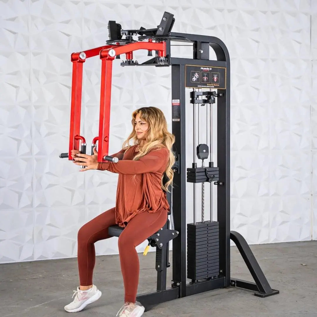 Woman performing a chest press on a black and red selectorized pec and rear delt combo machine with weight stack visible on the right side.