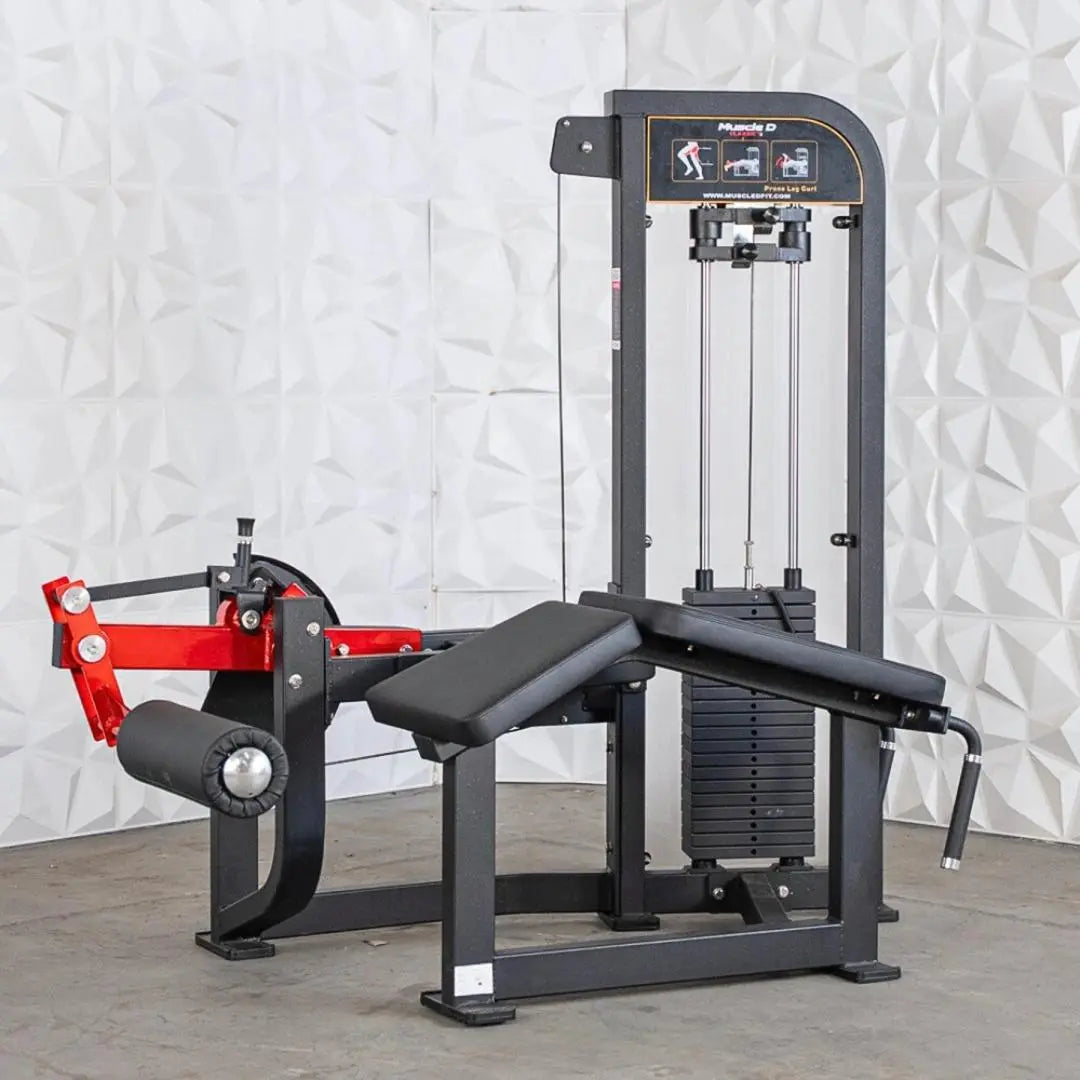 Black and red selectorized prone leg curl machine with padded seat, weight stack on right side, and instruction placard on upper frame.