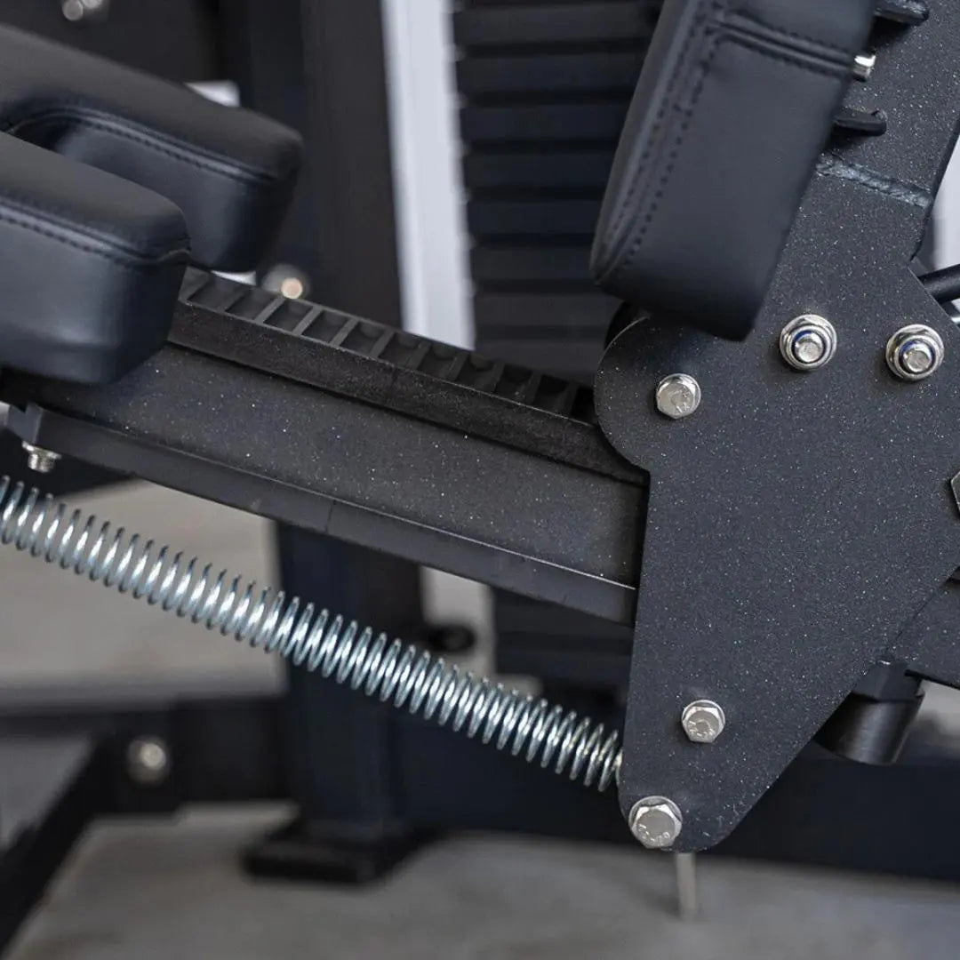 Close-up of seated leg curl machine components showing black padded leg attachment with metal adjustment bolts, chrome hardware, and threaded rod mechanism.