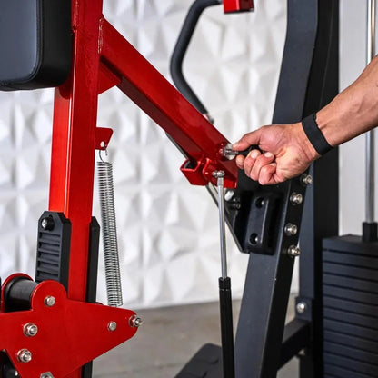 Man operating a red and black seated row machine with coiled spring resistance and metal adjustment handles against a white textured background.
