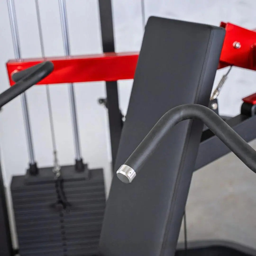 Close-up of a selectorized shoulder press machine with black padded seat back, curved black handlebar with metal grip, and red frame accents against a white and gray background.