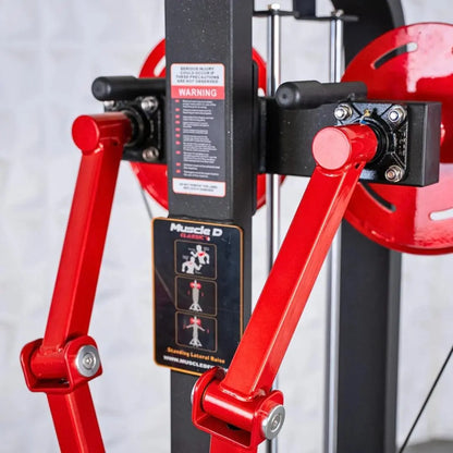 Red and black selectorized standing lateral raise machine with dual arm handles, weight stack, and instruction decals on the black frame.