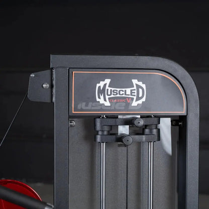 Muscled Classic V2 selectorized triceps extension machine with dark gray frame and orange accent trim against a black background.
