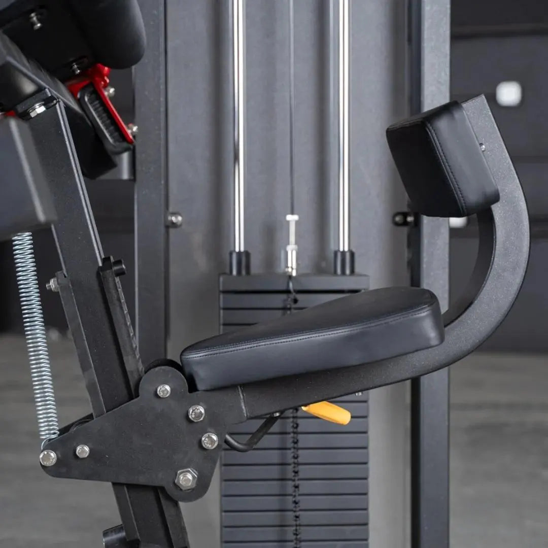 Commercial triceps extension machine with black padded arm rest and seat, chrome vertical guide rods, and weight stack visible in background.