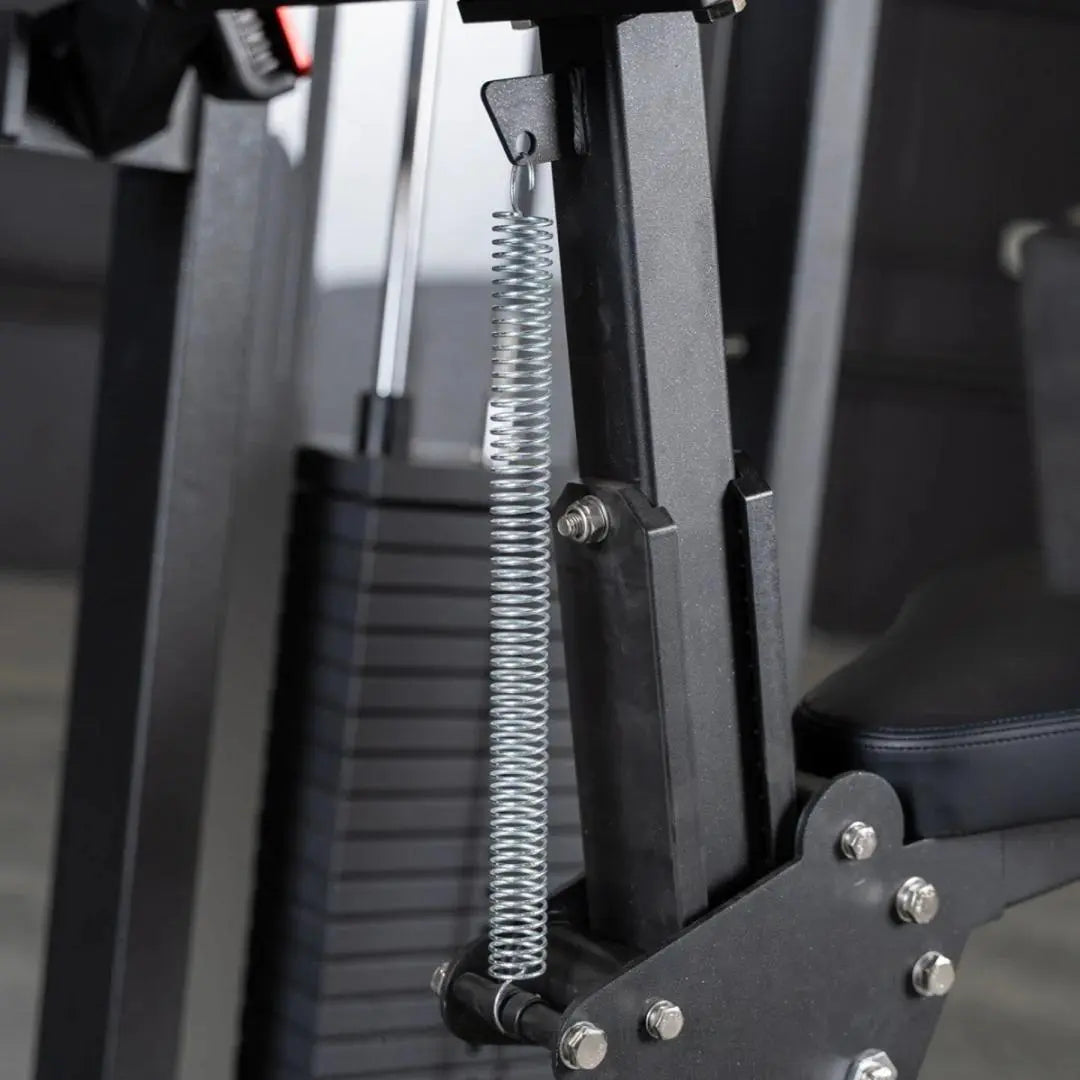 Close-up of the spring-loaded cable attachment and black metal frame on a triceps extension machine, showing the coiled steel cable and adjustment hardware.