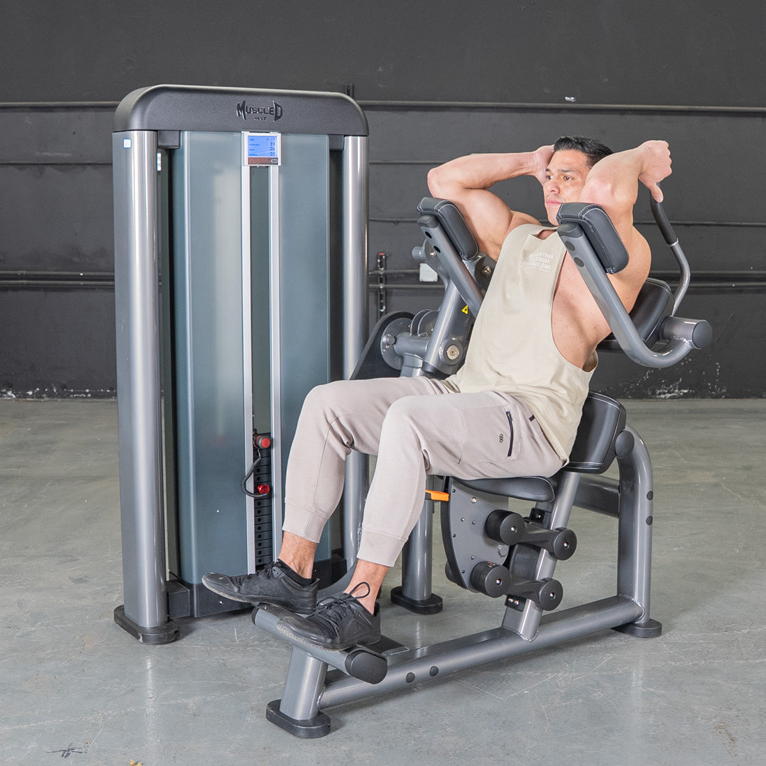 Man using Muscle D tricep extension machine in a gym.