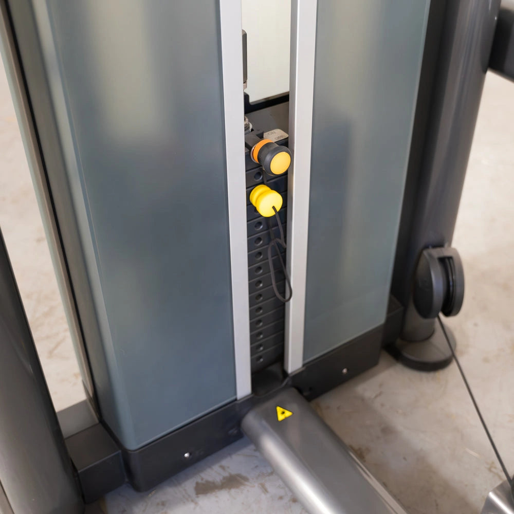 Close-up view of weight stack pins on an outer thigh exercise machine.