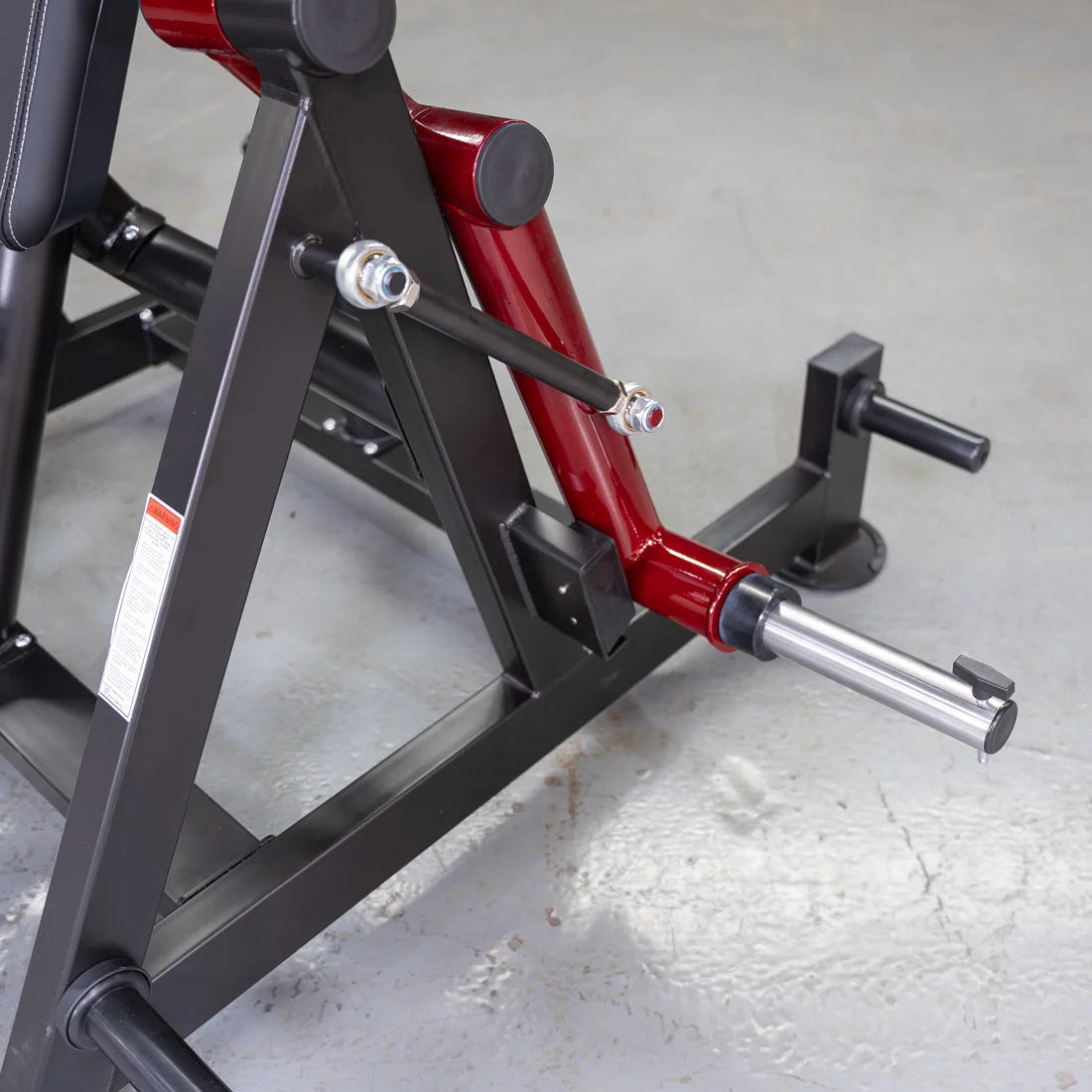 Red and black lever-based triceps machine with hammer grip handle.