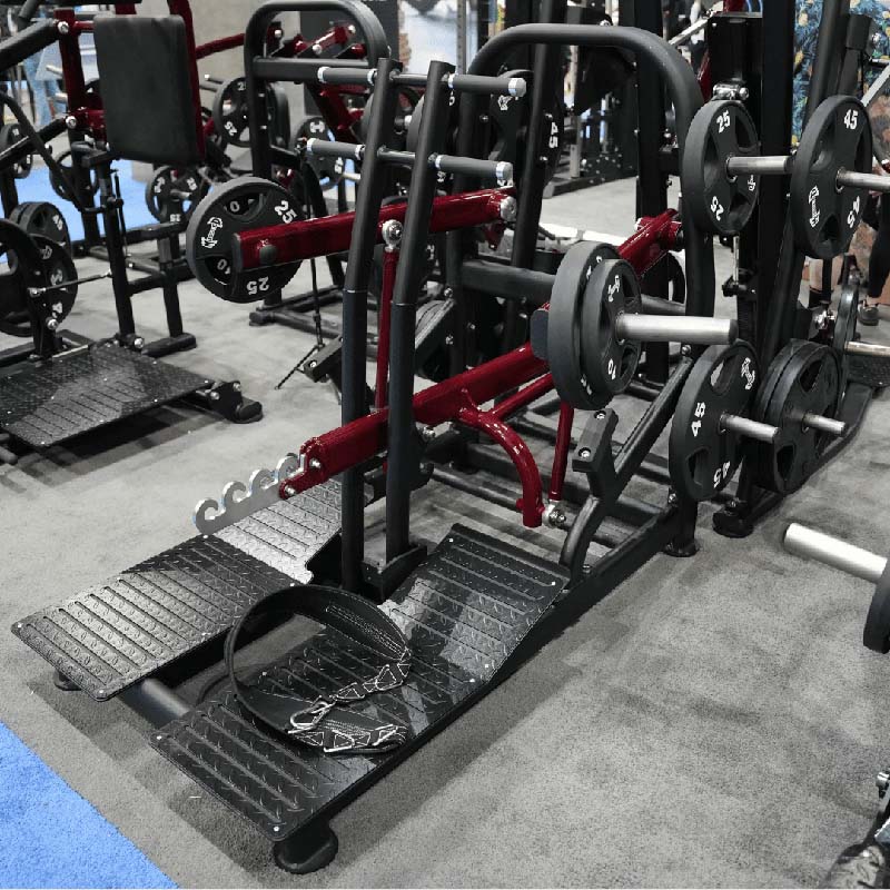 Pro strength belt squat machine with weight plates in a gym setting.