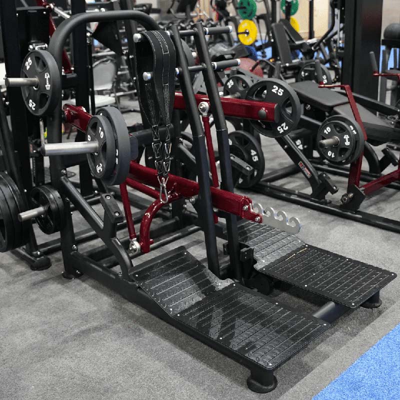 Muscle D Fitness Pro Strength belt squat machine with foot platforms in gym.