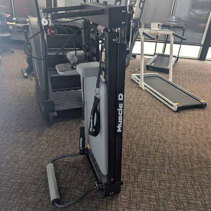 Gym weight machine with padded seat and pulley arms, labeled Muscled.