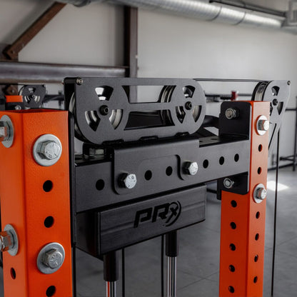 Industrial gym machine with orange steel frame, pulleys, and cables.