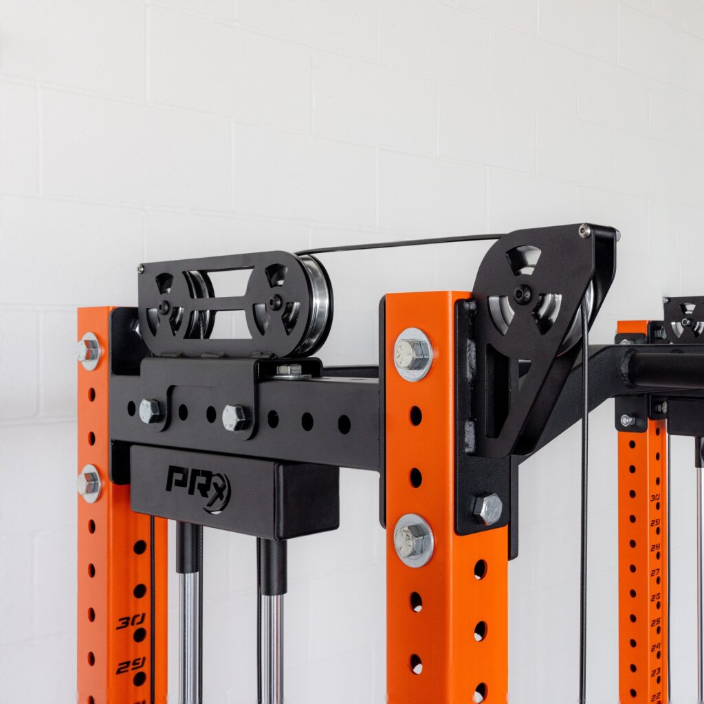 Orange and black weight machine with pulleys on a power rack.