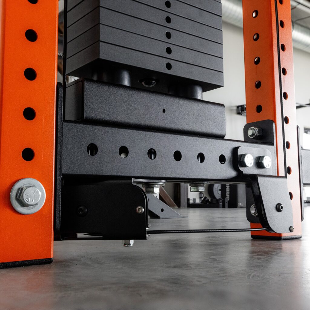 Industrial machine with orange steel frame and black hydraulic components.