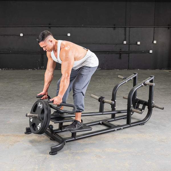 Man using a T-Bar Row Machine for back workout in a gym setting.
