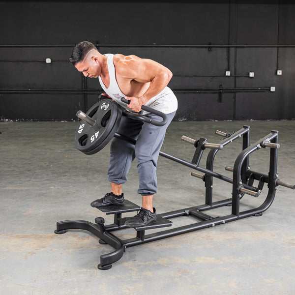 Man using T-Bar Row Machine with 45 lb weight plate for back exercises in gym.