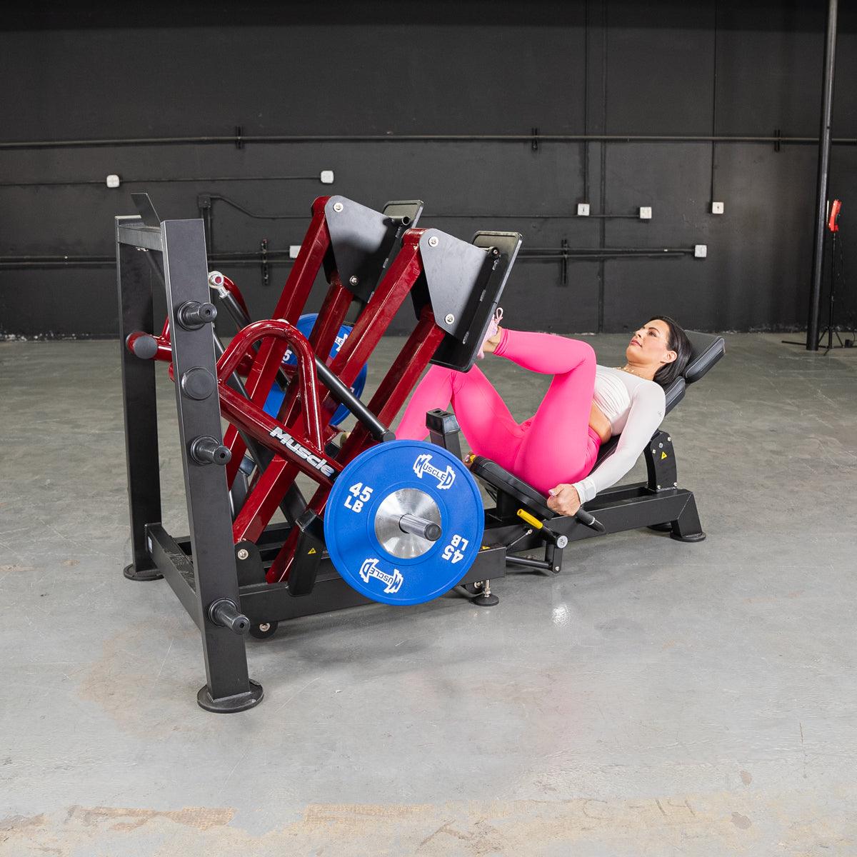 Woman using a 45-degree iso-lateral leg press machine in the gym.