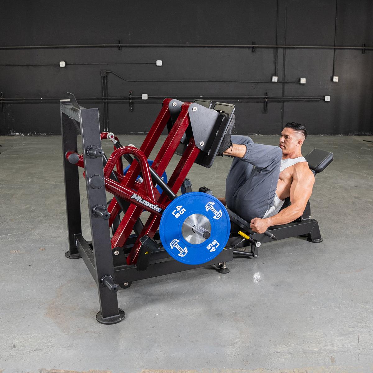 Man using a 45-degree iso-lateral leg press with blue weight plates.