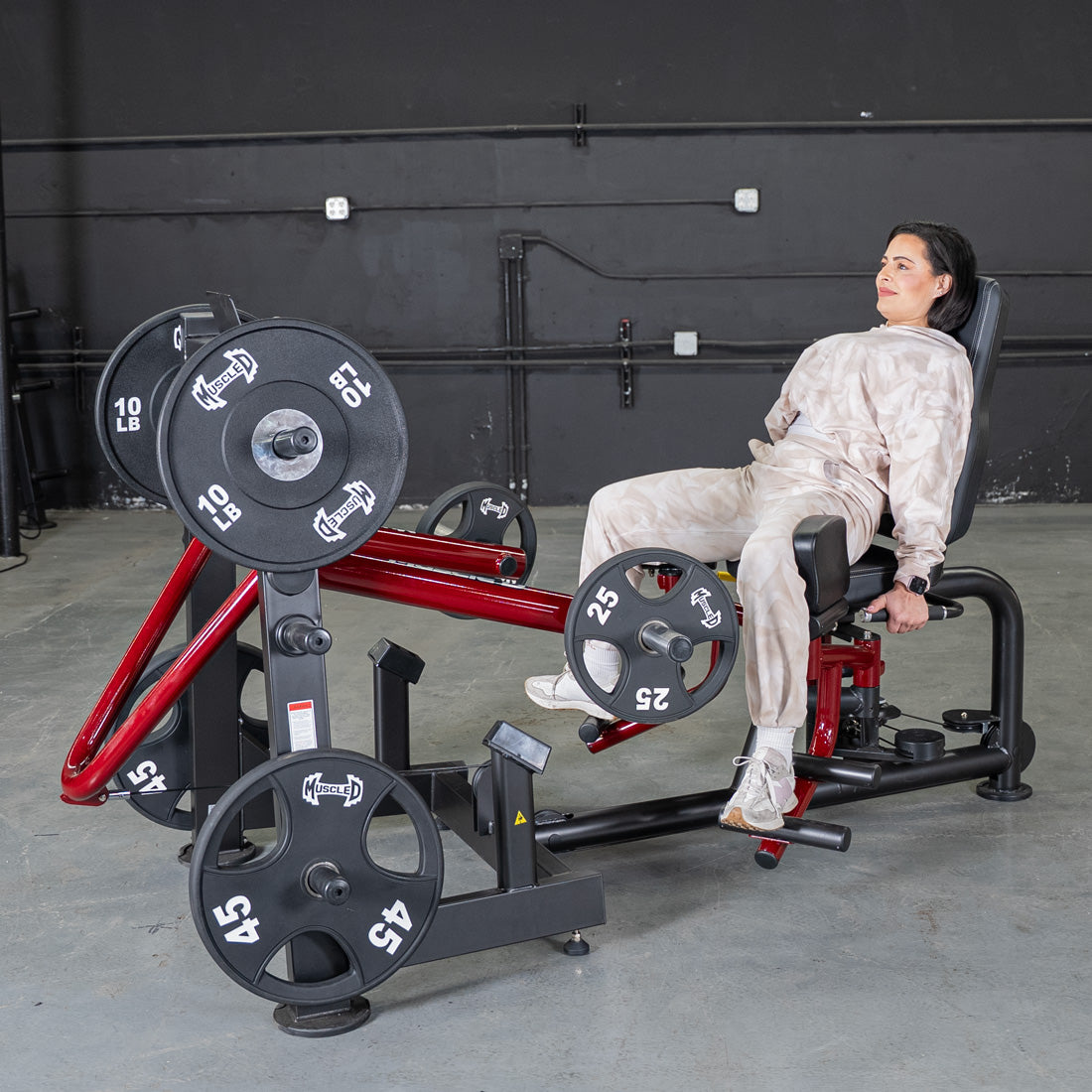 Woman seated on a Power Leverage Abductor/Adductor machine with weights in a gym.
